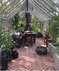 an instagramted photo of a patio with potted plants on the floor and tables in the middle