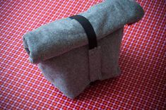 a gray bag sitting on top of a red and white checkered table cloth