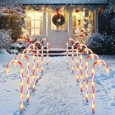 candy canes in front of a house decorated for christmas