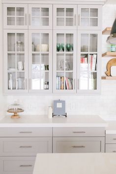 a kitchen with white cabinets and counter tops