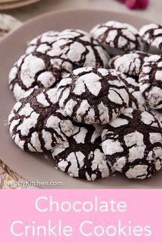 chocolate crinkle cookies on a plate with pink and white flowers in the background