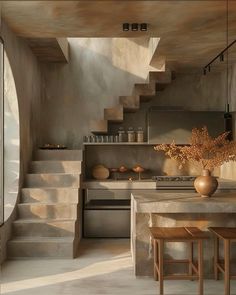 a kitchen with stairs leading up to the upper floor