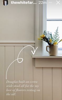 a vase with flowers sitting on top of a window sill next to a wall