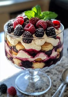 a trifle with berries and cream in a glass dish