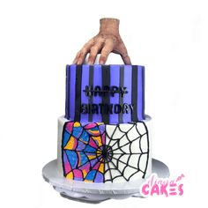 a birthday cake decorated with spider webs and hand on top