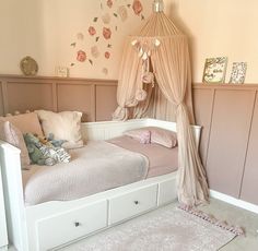 a white bed sitting in a bedroom next to a pink wall