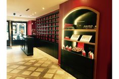 the interior of a store with red and black shelves