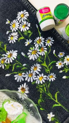 some paint sitting on top of a table next to a plate with flowers painted on it