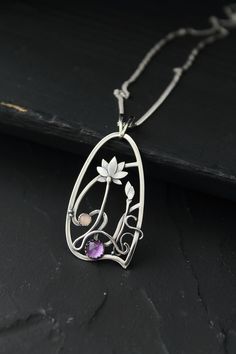 The size H 4 cm x W 3 cm (1 3/4 x 1 inch). Weight - 6g. You can buy it with the chain or without. The most delicate flower of the lotus can make someone very happy. I made this botanical jewelry of sterling silver, amethyst, and peach moonstone. This is a true work of art. It will emphasize your exquisite taste and status, and will also bring a lot of compliments. Lotus flower earrings https://www.etsy.com/listing/676137548/lotus-flower-earrings-sterling-silver?ref=shop_home_active_2&frs=1 O Purple Amulet Jewelry As Gift, Purple Amulet Style Jewelry Gift, Purple Amulet Jewelry As A Gift, Wire Wrapped Flower Pendant Jewelry Gift, Amethyst Large Pendant Jewelry Gift, Silver Gemstone Jewelry In Art Nouveau Style, Collectible Silver Necklace Nature-inspired, Art Nouveau Silver Gemstone Jewelry, Art Nouveau Purple Jewelry For Gift