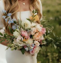 a woman holding a bouquet of flowers in her hands