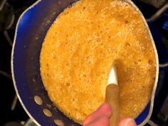 a person stirring something in a blue pan