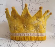 a yellow felt crown sitting on top of a table