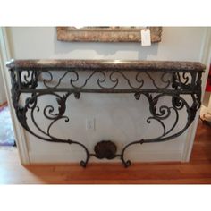 an iron console table with marble top in a living room or dining room area,