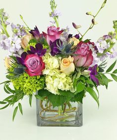 a vase filled with lots of different colored flowers