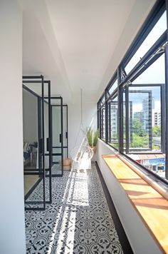 an empty room with large windows and tiled flooring