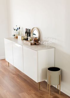 a white cabinet sitting on top of a hard wood floor next to a wine glass rack