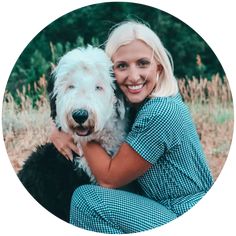 a woman is hugging her dog in the grass