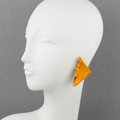 This is part of Chairish’s Costume Jewelry assortment.  Beautiful oversized Lucite clip-on earrings designed by Harriet Bauknight for Kaso. A geometric triangle shape features a dimensional layer with a neon orange mirror-textured pattern and large beveling. The Kaso brand paper sticker was removed, but the gray background and the specific rotating clip fastening are unmistakable brand signatures. Harriet Bauknight is an American Fashion designer who worked in the 1980s and the 1990s under the b Modern Yellow Earrings For Party, Modern Triangle Party Earrings, Modern Triangle Earrings For Party, Orange Mirror, American Fashion Designers, Geometric Triangle, Antique Earrings, Accessories Jewelry Earrings, Triangle Shape