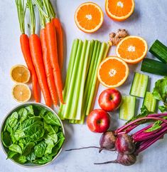 carrots, celery, radishes, and oranges on a table