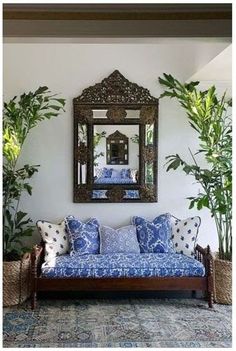 a living room with couches, mirrors and potted plants