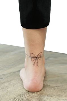 a woman's foot with a bow tattoo on it