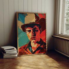 a painting of a man in a cowboy hat on a wall next to books and a window