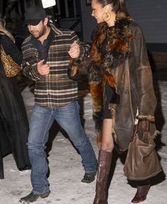 a man and woman walking in the snow