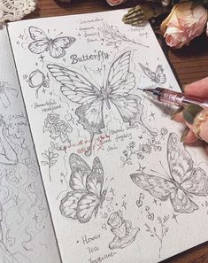 a person holding a pen and drawing butterflies