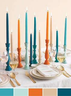 there are many different colored candles on the table