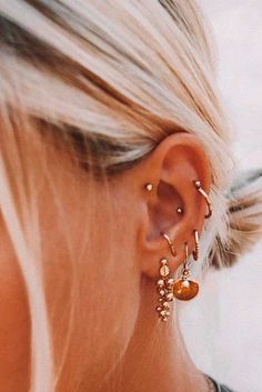 a woman with blonde hair wearing gold earrings