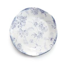 a blue and white plate with floral designs on the rim, against a white background