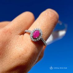 Genuine Ruby Oval Faceted Halo Sterling Silver Ring Add this beautiful pink Ruby halo ring and elevate your jewelry collection. This ring boasts an oval cut natural Ruby gemstone that exudes elegance and sophistication. The accented halo twinkles around the opaque Ruby, while the pave band will take your breath away with its sparkling accent stones. Whether you're treating yourself or looking for the perfect gift for a loved one, this Ruby ring is a beautiful choice for someone looking for a memorable design. Makes a stunning gift for a July birthday recipient as Ruby is the July birthstone. Ruby is considered a stone of love and vitality. Ruby is part of the Corundum crystal family and gets its beautiful pink tones from trace mineral elements of chromium. Sizes Available: 5, 7, 8, 9 DIMEN Dazzling Oval Ruby Ring With Halo Setting, Oval Ruby Halo Ring With Brilliant Cut, Oval Ruby Ring With Diamond Halo, Dazzling Oval Ruby Promise Ring, Dazzling Oval Ruby Ring In White Gold, Oval Ruby Halo Ring Fine Jewelry, Dazzling Oval White Gold Ruby Ring, Oval Ruby Ring With Halo In Fine Jewelry Style, Pink Oval Ruby Ring With Halo Design