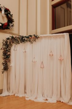 a white backdrop with candles and greenery on it