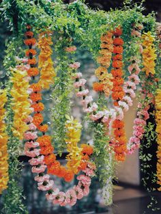 colorful flowers hanging from the ceiling in front of a building