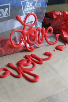 red plastic letters spelling out the word love on top of a bag of chocolate candies