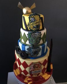 a multi tiered cake with hogwart's crests on it