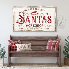 a wooden bench sitting in front of a white wall with santa's workshop on it