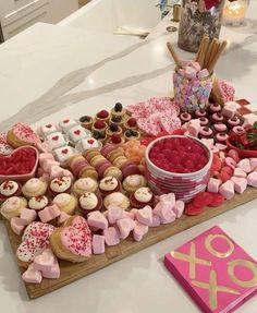 a wooden tray topped with lots of cupcakes next to a valentine's day card