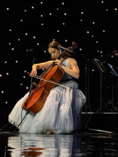 a woman in a white dress playing an instrument