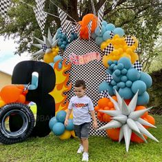 a young boy standing in front of a giant balloon decoration