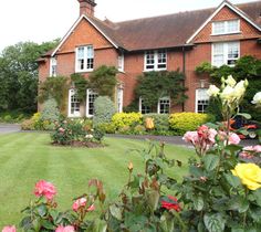 a large house with lots of flowers in the front yard