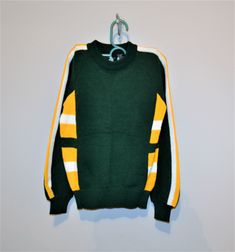 Vintage boys sweater in excellent, unworn condition. The original tag is on sweater. The shirt is green, gold and white. Great ski, school or Green Bay fan sweater. The gold and white stripes are very retro, 80's. Created for Meijer by Timber Ridge. Non itch acrylic. Measurements: Label size medium Chest-30 inches Length-21 inches fits like size small to medium Thanks-fresh inventory daily: https://www.etsy.com/shop/Christmasvintage Created by: https://www.etsy.com/shop/CheekyVintageCloset Sporty Winter School Sweater, Winter College Sweater With School Spirit, Sporty Fall Sweater For School, Collegiate Winter Sweater For Sports, Collegiate Winter Sports Sweater, Green Varsity Sweater For Winter, Sporty Yellow Sweater For Fall, Sporty Yellow Fall Sweater, Sporty Tops With Ribbed Cuffs For School