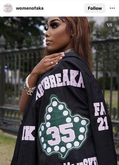 a woman wearing a black jacket with the number 55 on it's back and white polka dots