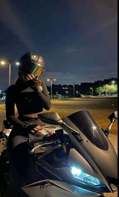 a woman sitting on top of a motorcycle at night