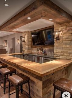 a bar with stools and a television mounted to the wall