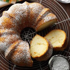 a bundt cake on a cooling rack with powdered sugar and two slices cut out