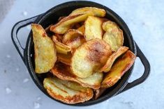 some fried food in a black bowl on a table