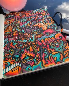 an open notebook with colorful drawings on it