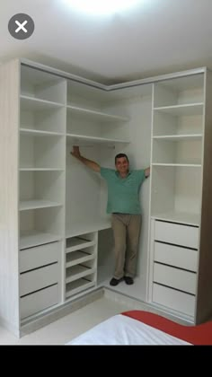 a man is standing in the closet with his arms out and hands on the shelves