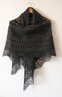 a black crocheted shawl hanging on a wall